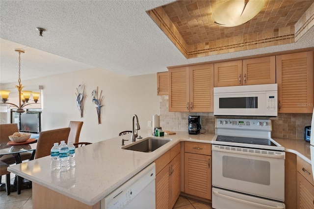 kitchen with sink, light tile patterned floors, white appliances, and kitchen peninsula