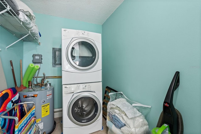 washroom featuring water heater, a textured ceiling, and stacked washing maching and dryer