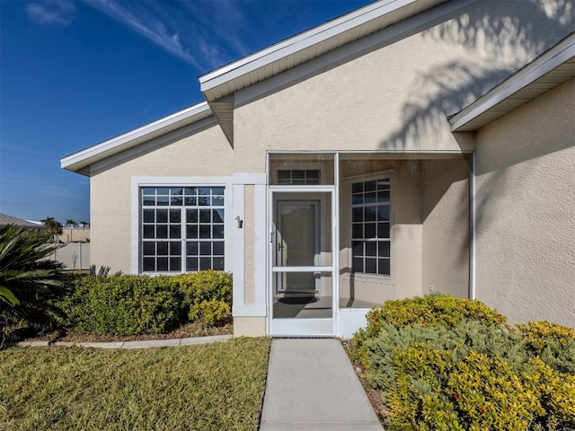 doorway to property featuring a lawn