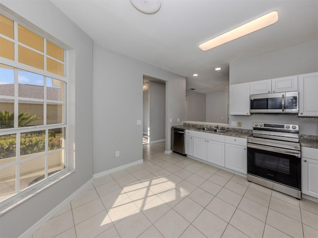 kitchen featuring white cabinetry, sink, light tile patterned floors, and stainless steel appliances