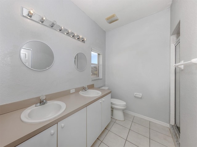 bathroom featuring tile patterned flooring, vanity, toilet, and an enclosed shower