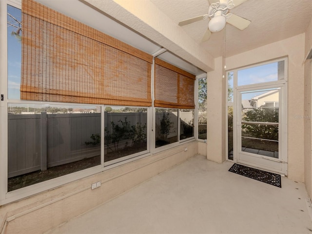 unfurnished sunroom with ceiling fan