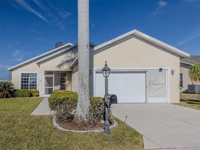 view of front of home featuring cooling unit, a garage, and a front lawn