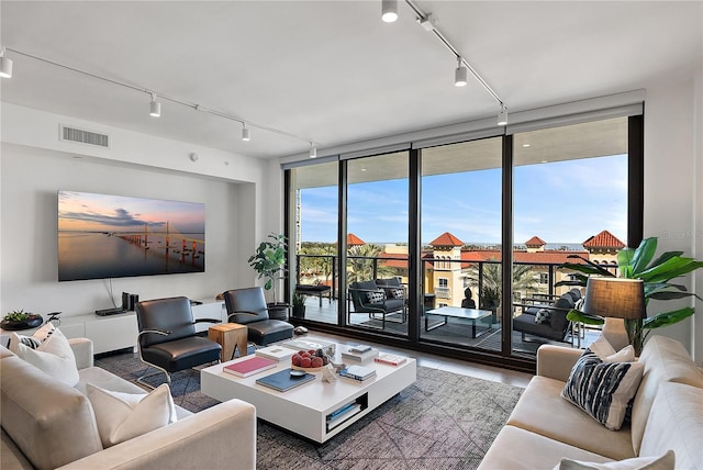 living room with expansive windows, rail lighting, and dark hardwood / wood-style flooring