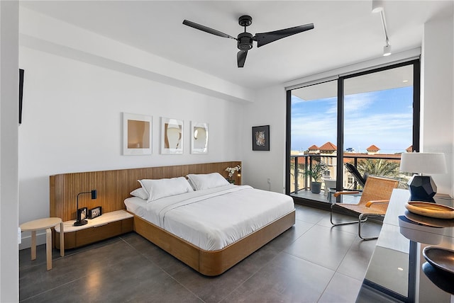 bedroom featuring expansive windows, rail lighting, access to outside, and ceiling fan