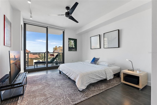 bedroom with expansive windows, track lighting, access to exterior, and ceiling fan