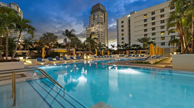 pool at dusk featuring a patio