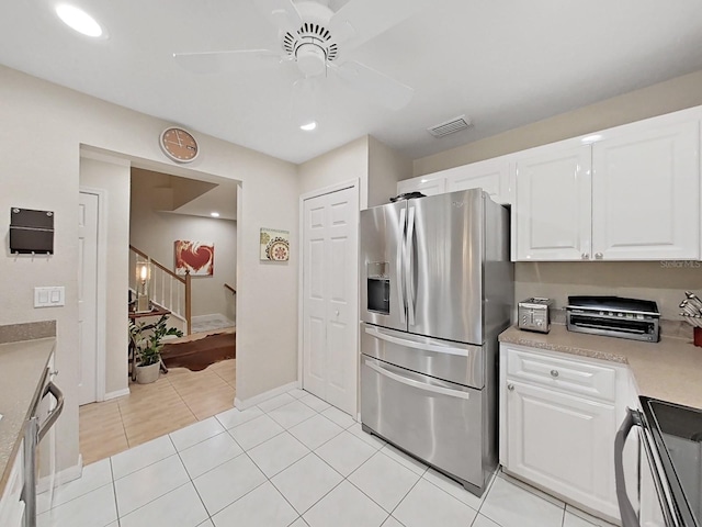 kitchen featuring light tile patterned flooring, appliances with stainless steel finishes, white cabinets, and ceiling fan