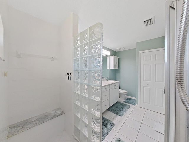 bathroom featuring walk in shower, vanity, toilet, and tile patterned flooring