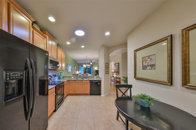 kitchen with pendant lighting, sink, black appliances, light tile patterned flooring, and kitchen peninsula