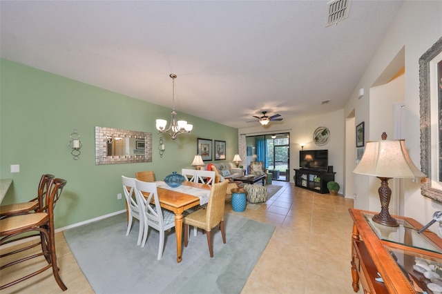 tiled dining room featuring ceiling fan with notable chandelier