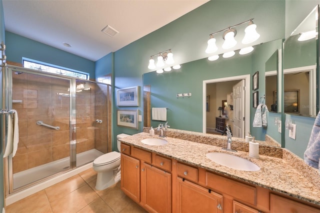 bathroom with tile patterned flooring, vanity, a shower with door, and toilet