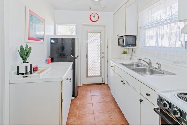 kitchen with range with electric cooktop, white cabinetry, sink, stainless steel fridge, and light tile patterned floors