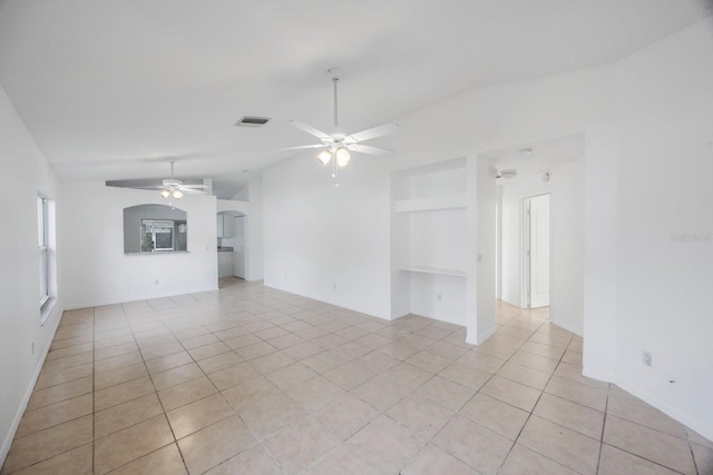 tiled spare room with vaulted ceiling and ceiling fan