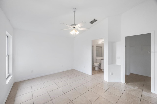 tiled empty room with lofted ceiling and ceiling fan