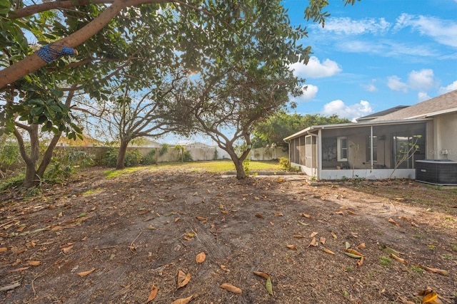 view of yard with central AC and a sunroom