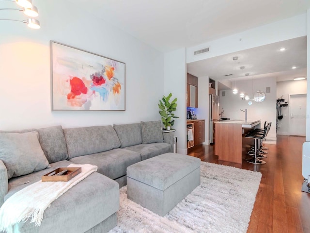 living room featuring dark wood-type flooring and a notable chandelier