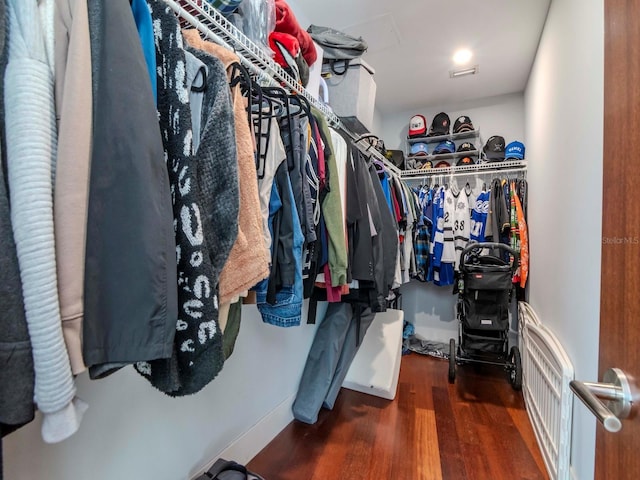 walk in closet with dark hardwood / wood-style flooring