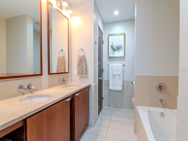 bathroom featuring a washtub, vanity, tile patterned floors, and tile walls