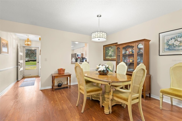 dining room featuring hardwood / wood-style flooring and a textured ceiling