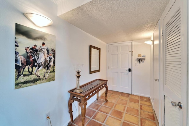 hall featuring a textured ceiling and light tile patterned floors