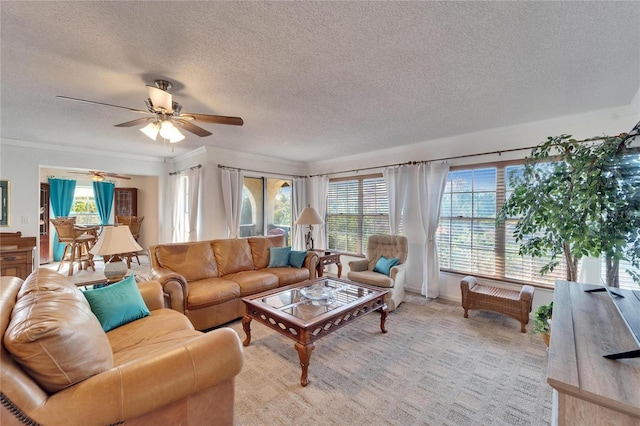 living room featuring ornamental molding, light carpet, ceiling fan, and a textured ceiling