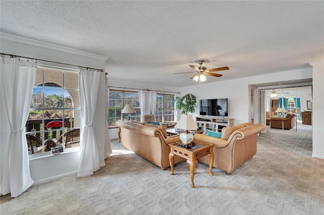 living room featuring a textured ceiling, ornamental molding, light colored carpet, and ceiling fan