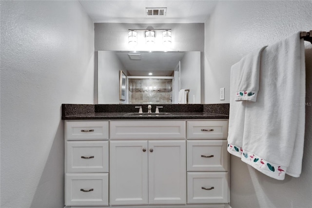 bathroom featuring vanity and a shower with door