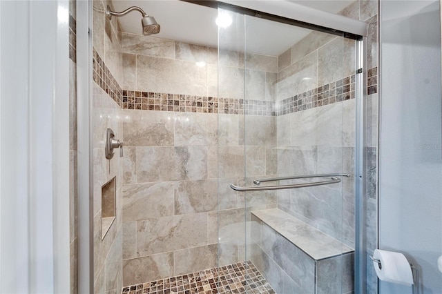 bathroom featuring a shower with shower door