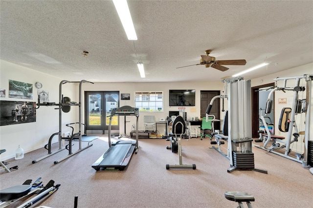 gym with ceiling fan, french doors, and a textured ceiling