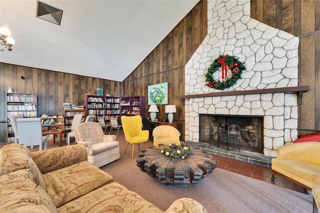 living room with a stone fireplace, high vaulted ceiling, and wooden walls