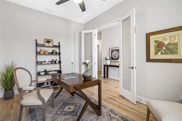 home office with light hardwood / wood-style floors, french doors, and ceiling fan