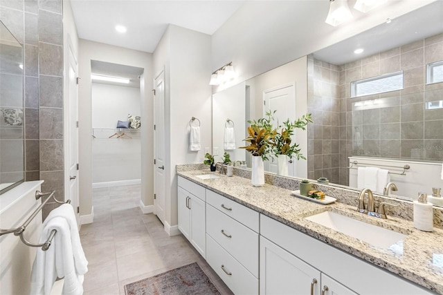 bathroom featuring vanity, tile patterned floors, and a tile shower