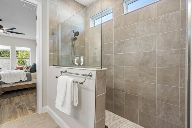 bathroom with tile patterned flooring, tiled shower, and ceiling fan