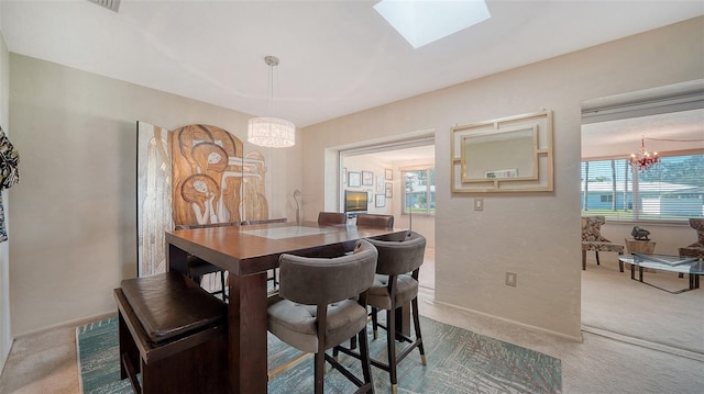 carpeted dining area featuring a skylight and a notable chandelier