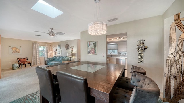 carpeted dining area featuring ceiling fan, a skylight, and sink