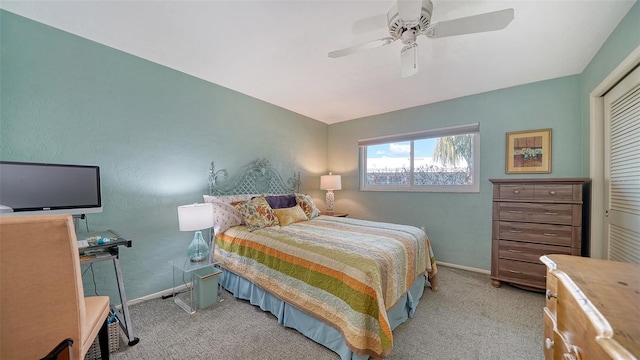 carpeted bedroom featuring ceiling fan and a closet