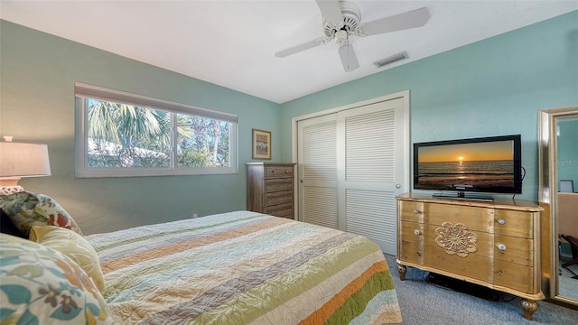 carpeted bedroom with ceiling fan and a closet