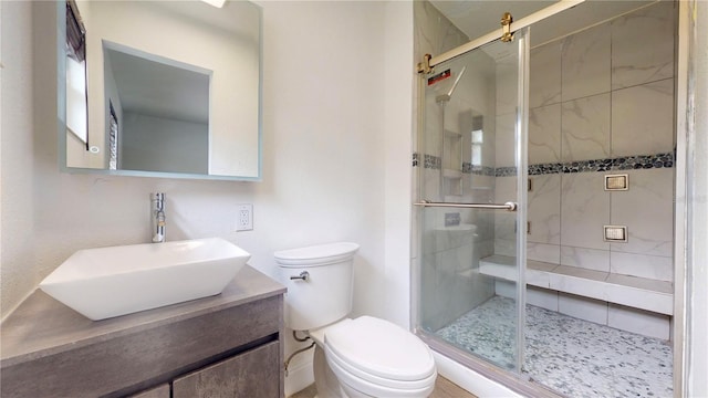 bathroom featuring vanity, an enclosed shower, and toilet