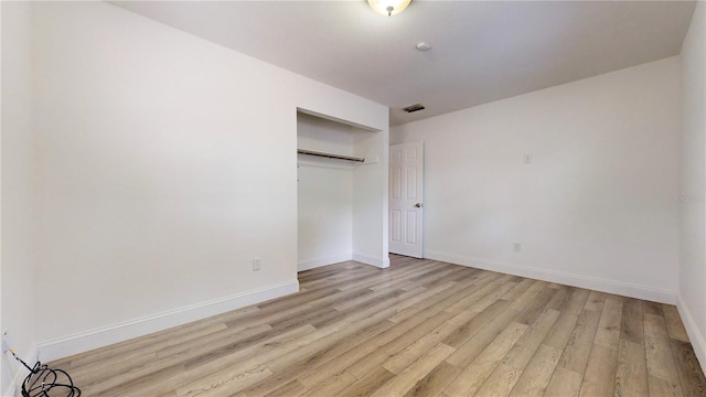 unfurnished bedroom with light hardwood / wood-style flooring and a closet