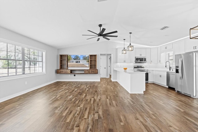 kitchen featuring pendant lighting, appliances with stainless steel finishes, wood-type flooring, and white cabinets