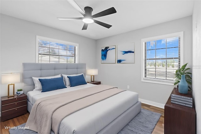 bedroom with ceiling fan, hardwood / wood-style floors, and multiple windows