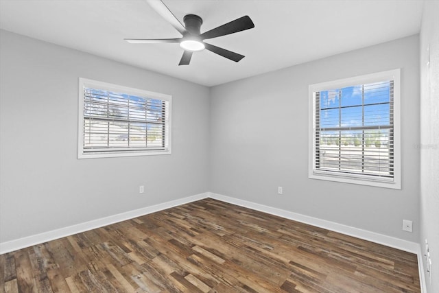 empty room featuring ceiling fan, dark hardwood / wood-style floors, and a wealth of natural light