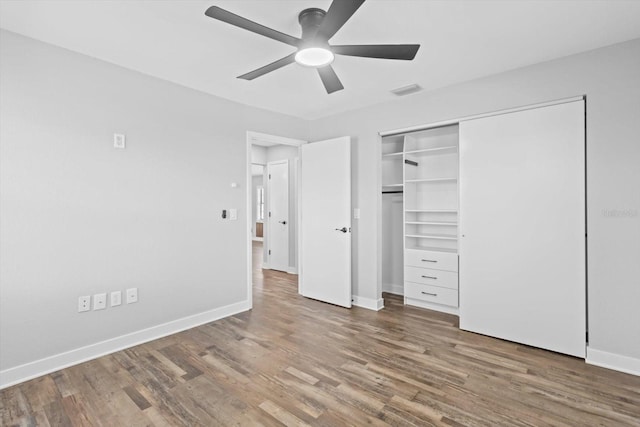 unfurnished bedroom featuring wood-type flooring, ceiling fan, and a closet