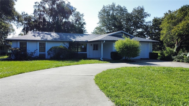 ranch-style house featuring a garage and a front yard