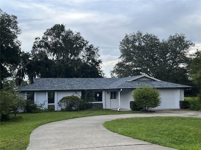 single story home featuring a garage and a front yard