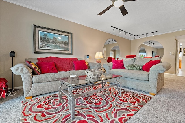 carpeted living room with crown molding, track lighting, ceiling fan, and a textured ceiling