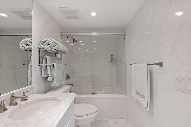 full bathroom featuring toilet, vanity, and bath / shower combo with glass door