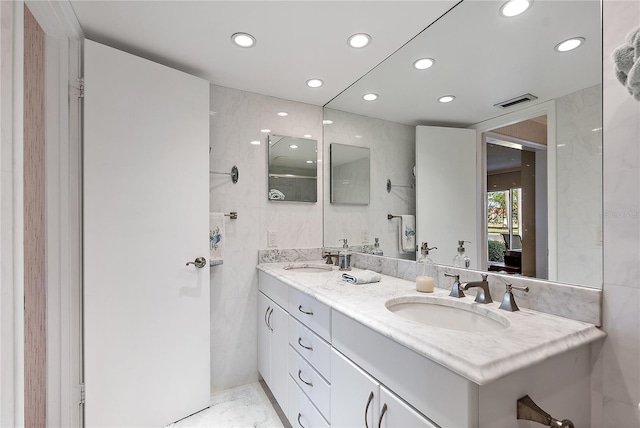 bathroom with vanity and tile walls