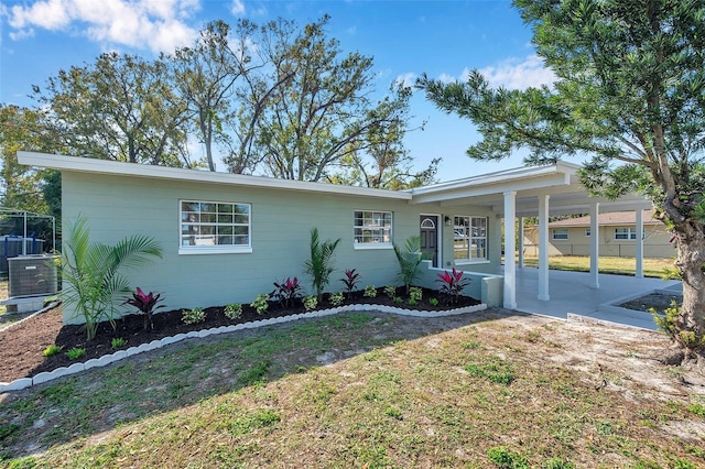 view of front of home featuring a carport, a front yard, and cooling unit